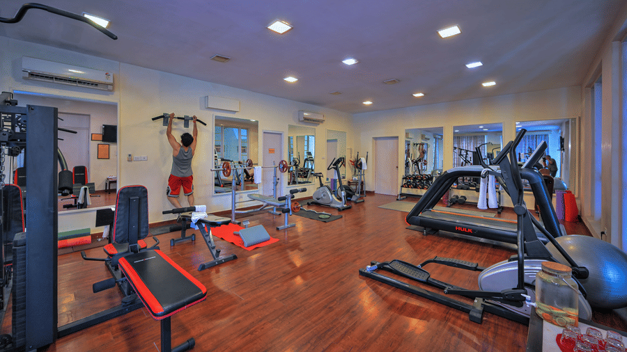 A gym area with treadmills, mirrors, and other gym equipments placed at The Clarks Varanasi.