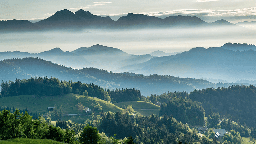An image of a mountain with clouds hovering over