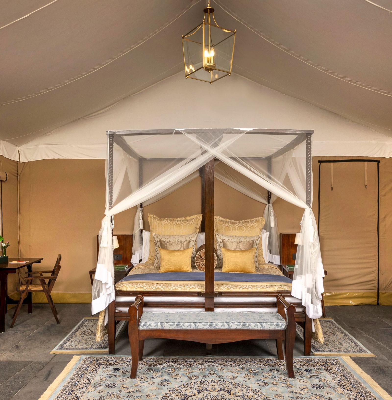 An image of a bed under a cosy lamp in our tents near Haridwar - Aalia Jungle Resort & Spa