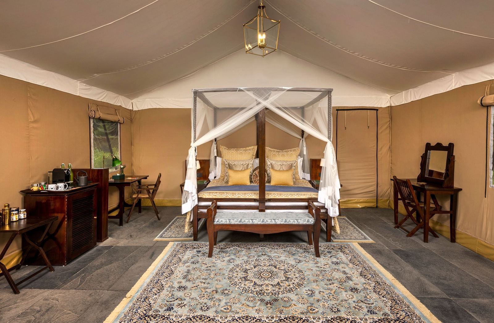 An image of a bed under a cosy lamp in our tents near Haridwar - Aalia Jungle Resort & Spa