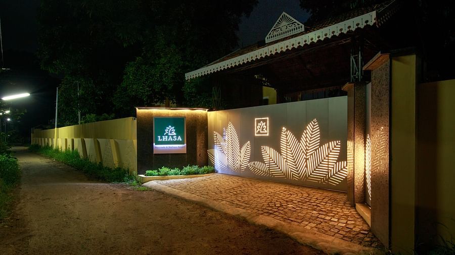 An outdoor view of a building at night with illuminated signage and a decorated wall.