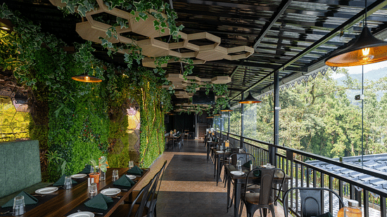 An outdoor dining area with a roof, offering expansive mountain views | Voyage The Royal Retreat, Gangtok