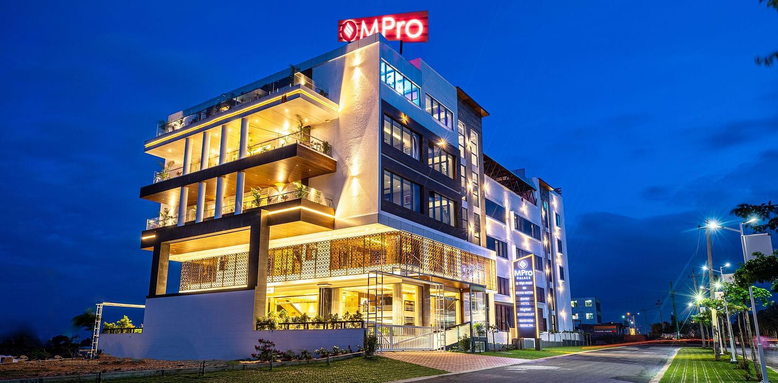A view of the M Pro Palace facade, illuminated by glowing lights from within.