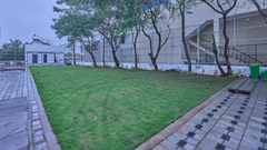 the lawn at Grand Continent, Mahabalipuram with trees on one side of it