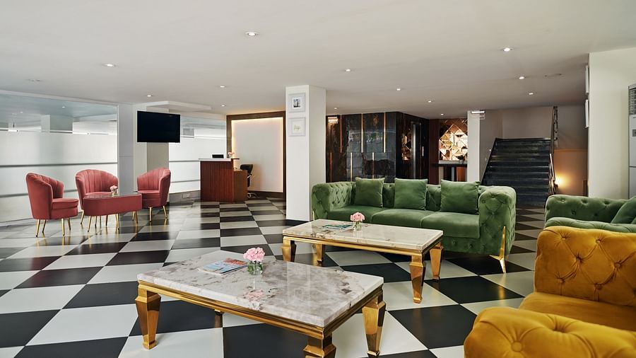 An image of our lounge with a comfortable sofas placed around a coffee table - Deventure Sarovar Portico, Patel Nagar