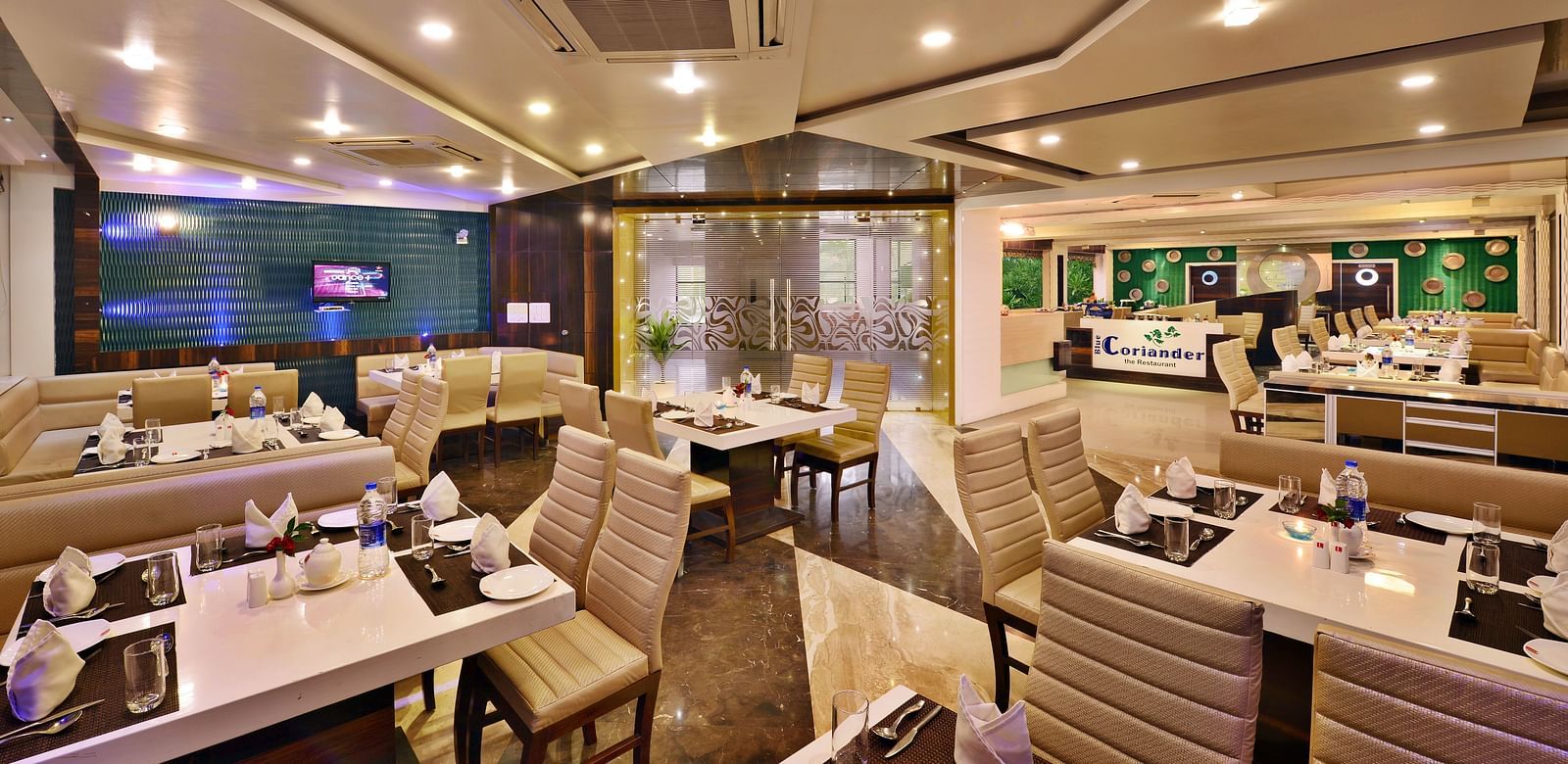 A modern hotel restaurant at Lords Inn Porbandar, showcases contemporary design and ample seating for guests.