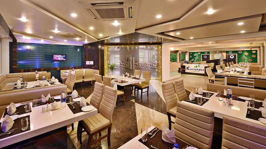 A modern hotel restaurant at Lords Inn Porbandar, showcases contemporary design and ample seating for guests.