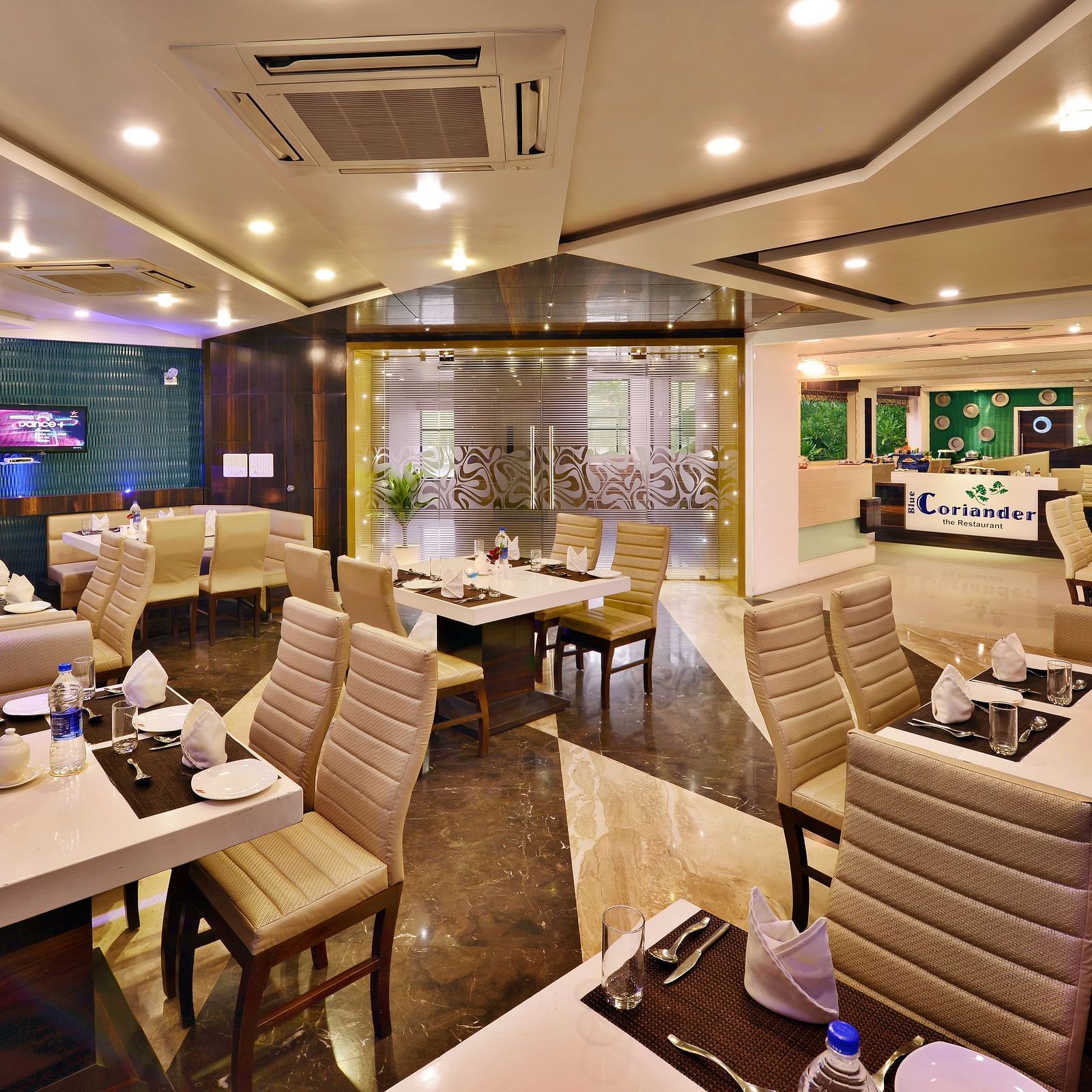 A modern hotel restaurant at Lords Inn Porbandar, showcases contemporary design and ample seating for guests.