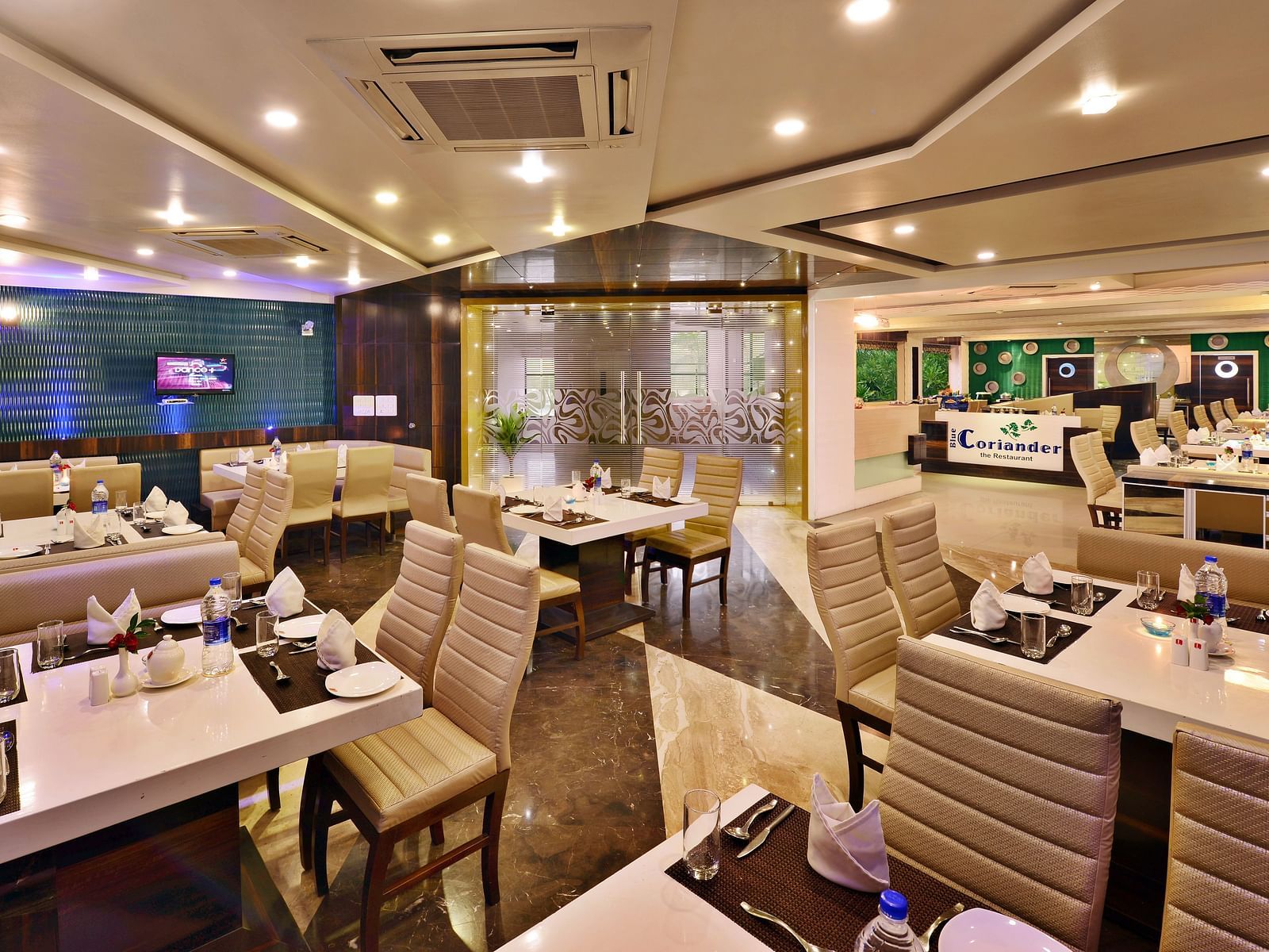 A modern hotel restaurant at Lords Inn Porbandar, showcases contemporary design and ample seating for guests.
