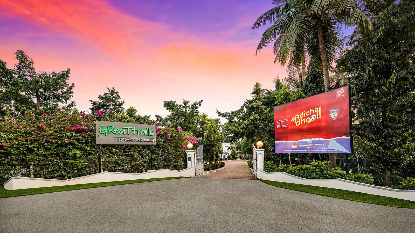 Facade image of the Entrance Gate of GReaT Trails River View Resort Thanjavur By GRT Hotels surrounded by lush greenery