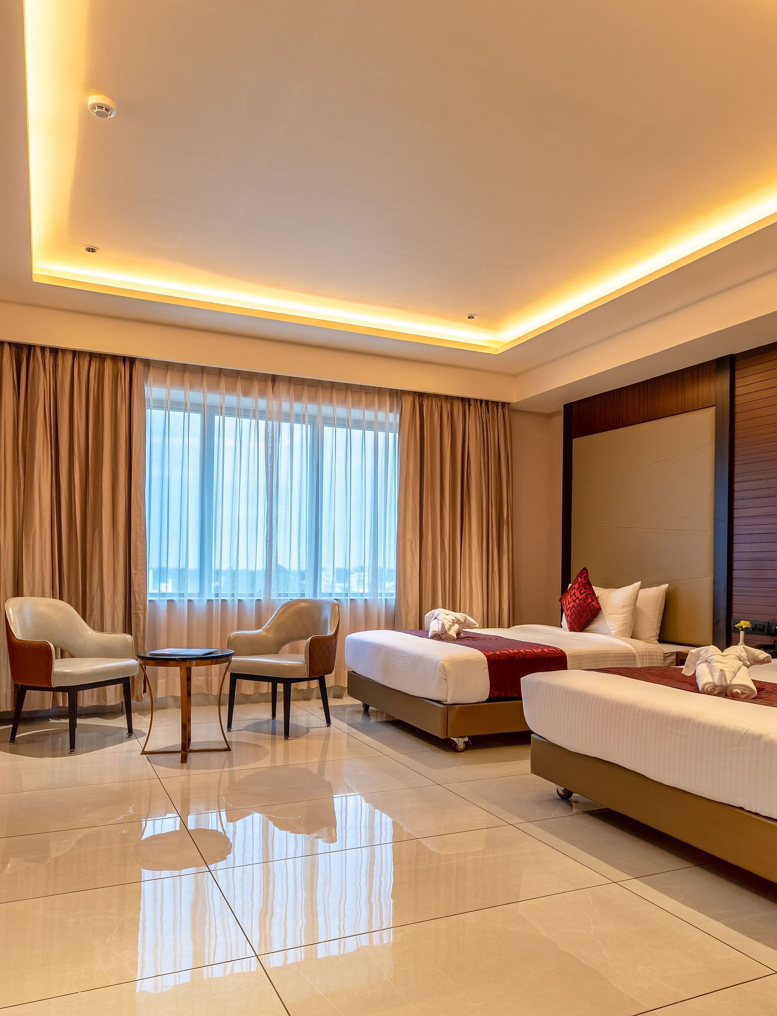 A side view of a room featuring two beds and a seating area in the corner at M Pro Palace.