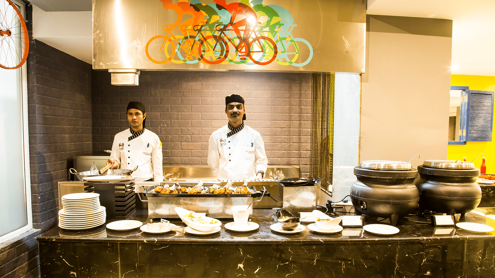 Two chefs standing in front of a buffet table with plates arranged  | Regency Tirunelveli By GRT Hotels 