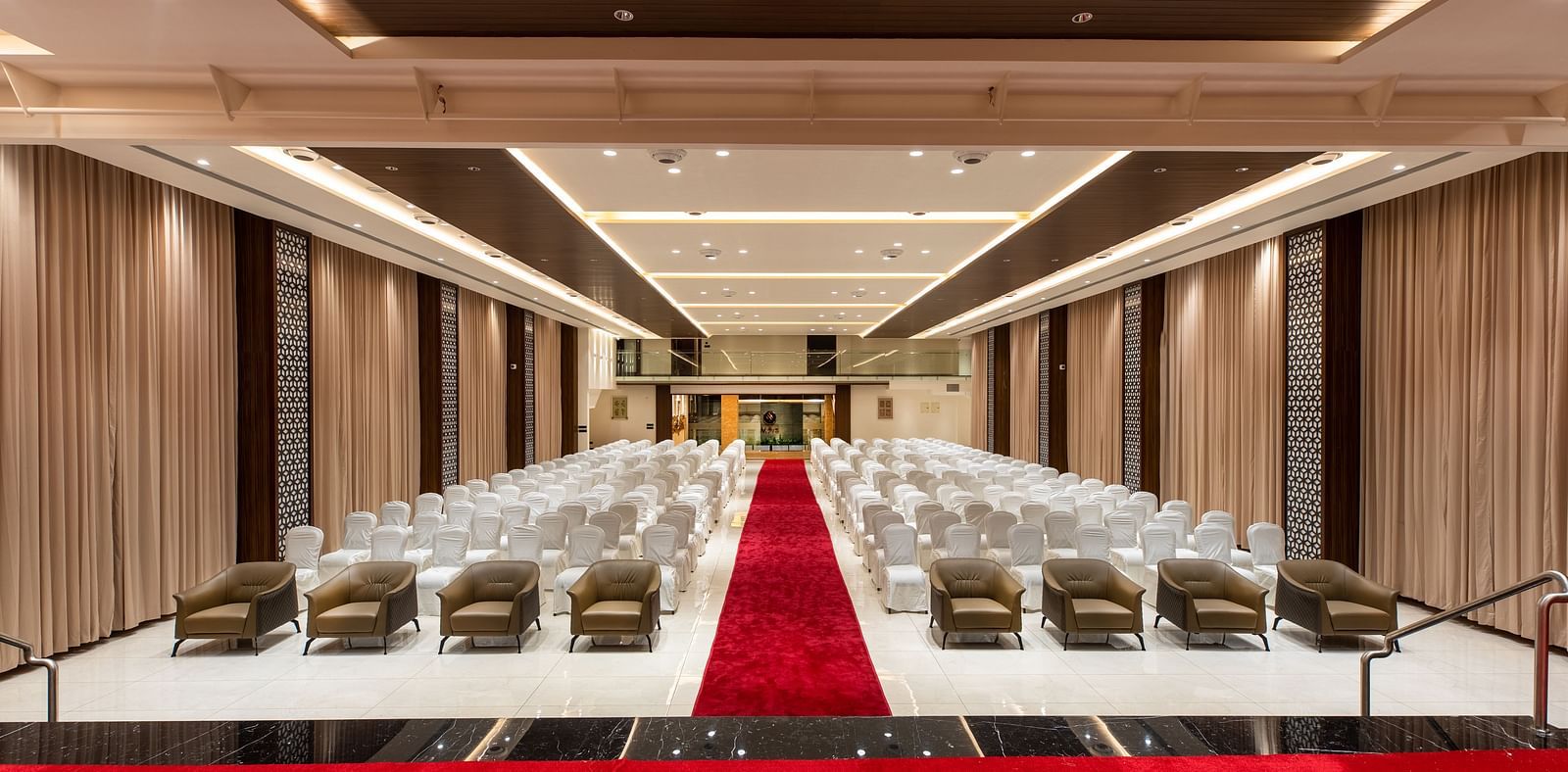 An image of a hall with chairs neatly arranged, with a carpet running between them at M Pro Palace.