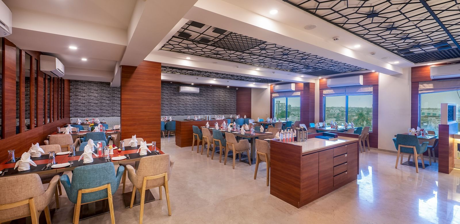 A well-lit dining area with buffet stations and tables with chairs.