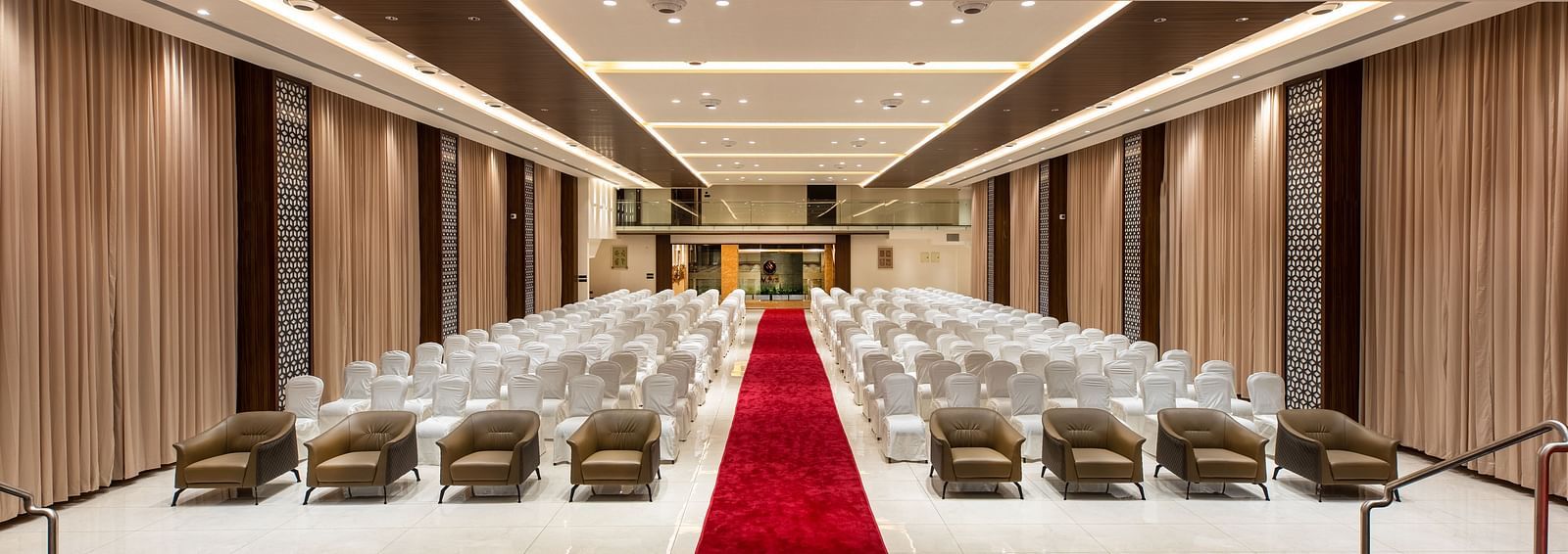 An image of a hall with chairs neatly arranged, with a carpet running between them at M Pro Palace.