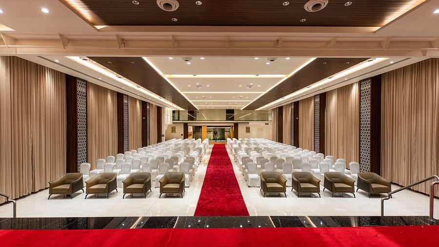 An image of a hall with chairs neatly arranged, with a carpet running between them at M Pro Palace.