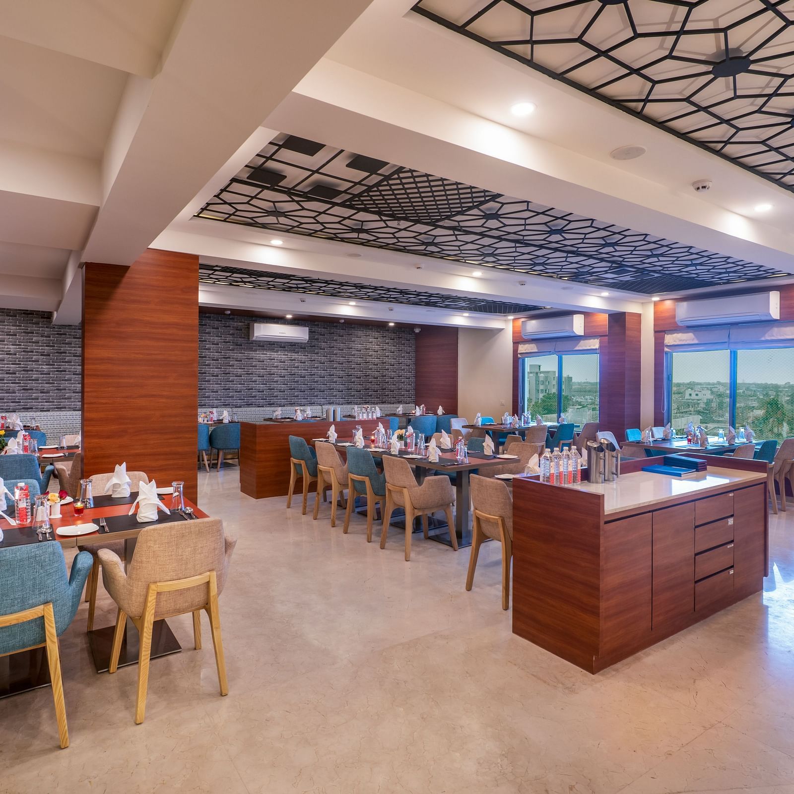Spacious restaurant with neatly arranged tables and comfortable seating in Lords Eco Inn Shapar Rajkot