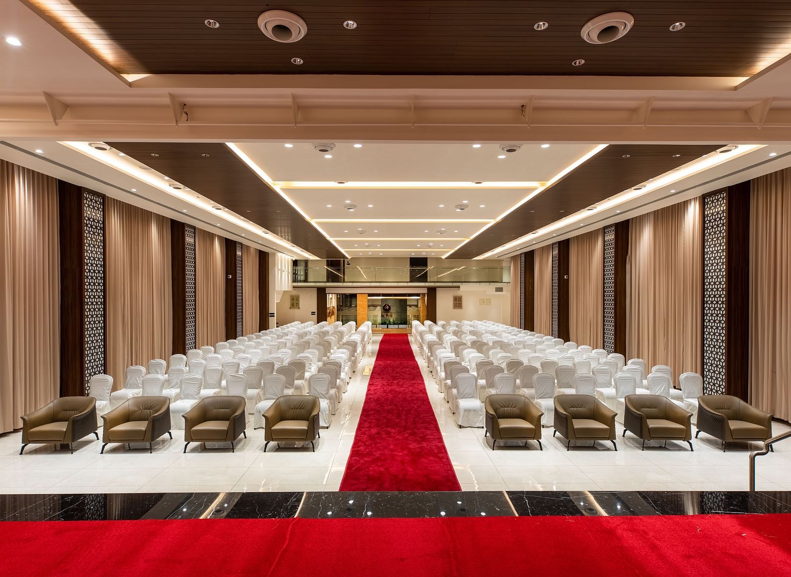 An image of a hall with chairs neatly arranged, with a carpet running between them at M Pro Palace.