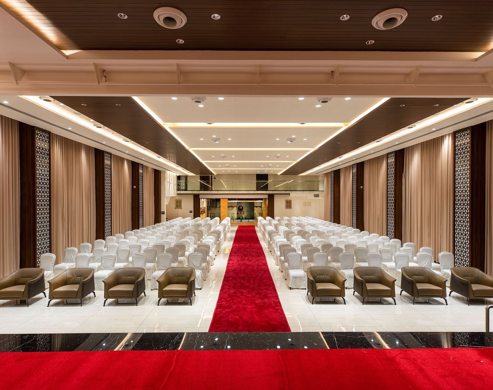 An image of a hall with chairs neatly arranged, with a carpet running between them at M Pro Palace.