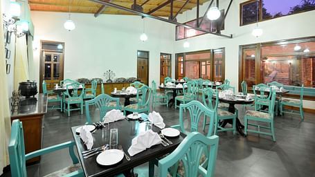 A vibrant dining area in Almora with well-arranged tables and chairs - BluSalzz Escapade - Anant Rasa Resort
