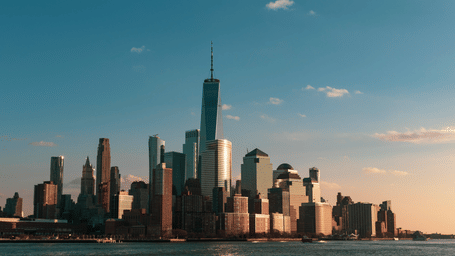 City skyline with tall modern skyscrapers against a clear blue sky, capturing an iconic urban destination.
