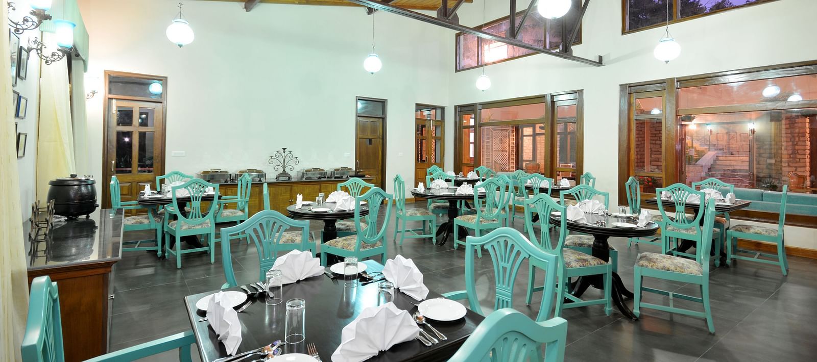 A vibrant dining area in Almora with well-arranged tables and chairs - BluSalzz Escapade - Anant Rasa Resort