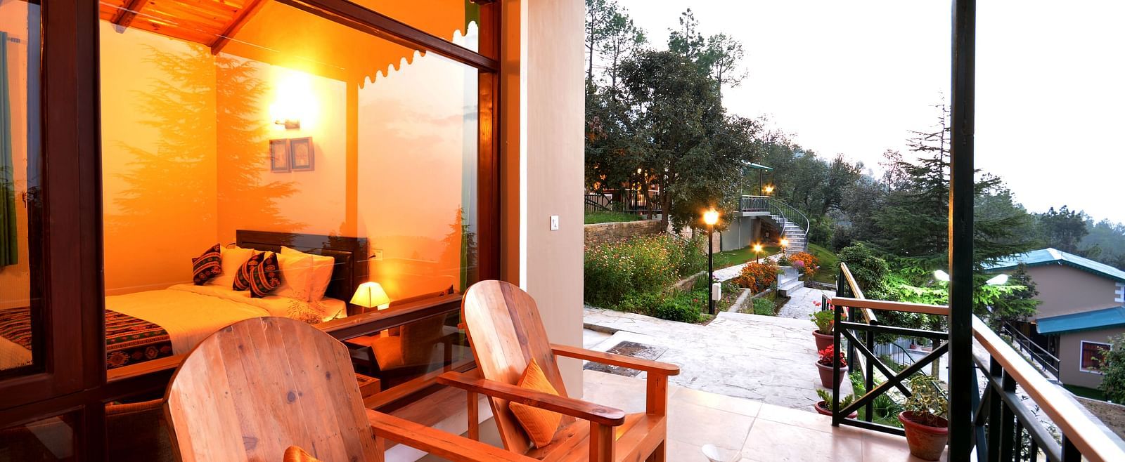 A seating area on a balcony with serene views of the surrounding greenery - BluSalzz Escapade - Anant Rasa Resort