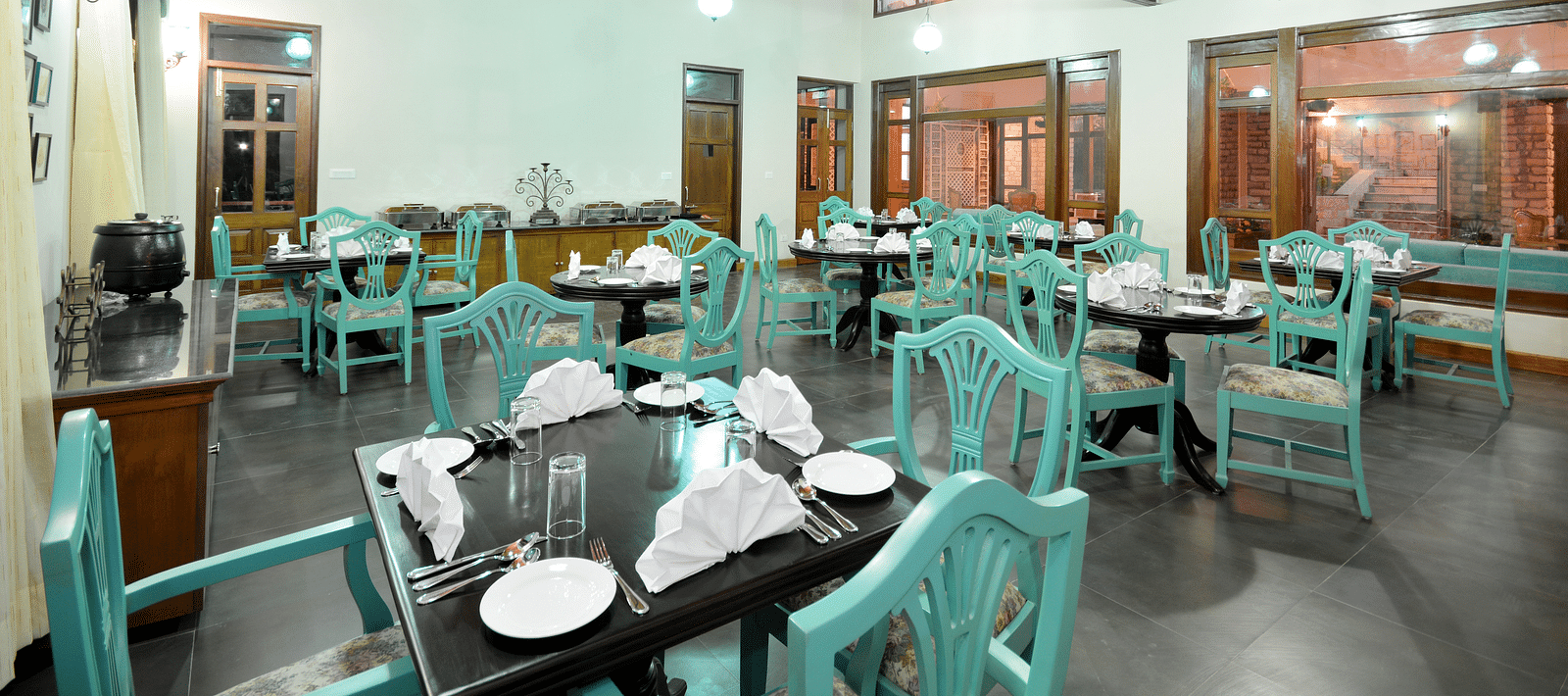 A vibrant dining area in Almora with well-arranged tables and chairs - BluSalzz Escapade - Anant Rasa Resort