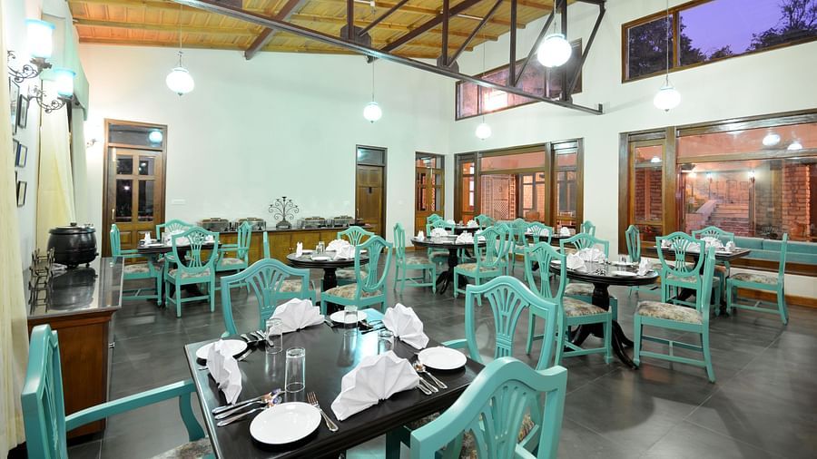 A vibrant dining area in Almora with well-arranged tables and chairs - BluSalzz Escapade - Anant Rasa Resort