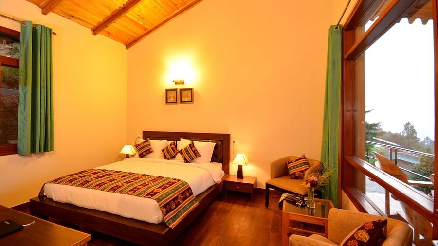 An elegantly furnished bedroom in Almora with soft lighting and large glass windows - BluSalzz Escapade - Anant Rasa Resort