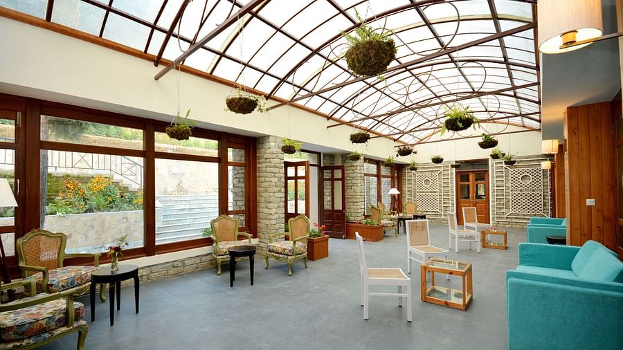 A side angle view of a lounge with sofas, coffee tables, and plants hung from the ceiling - BluSalzz Escapade - Anant Rasa Resort
