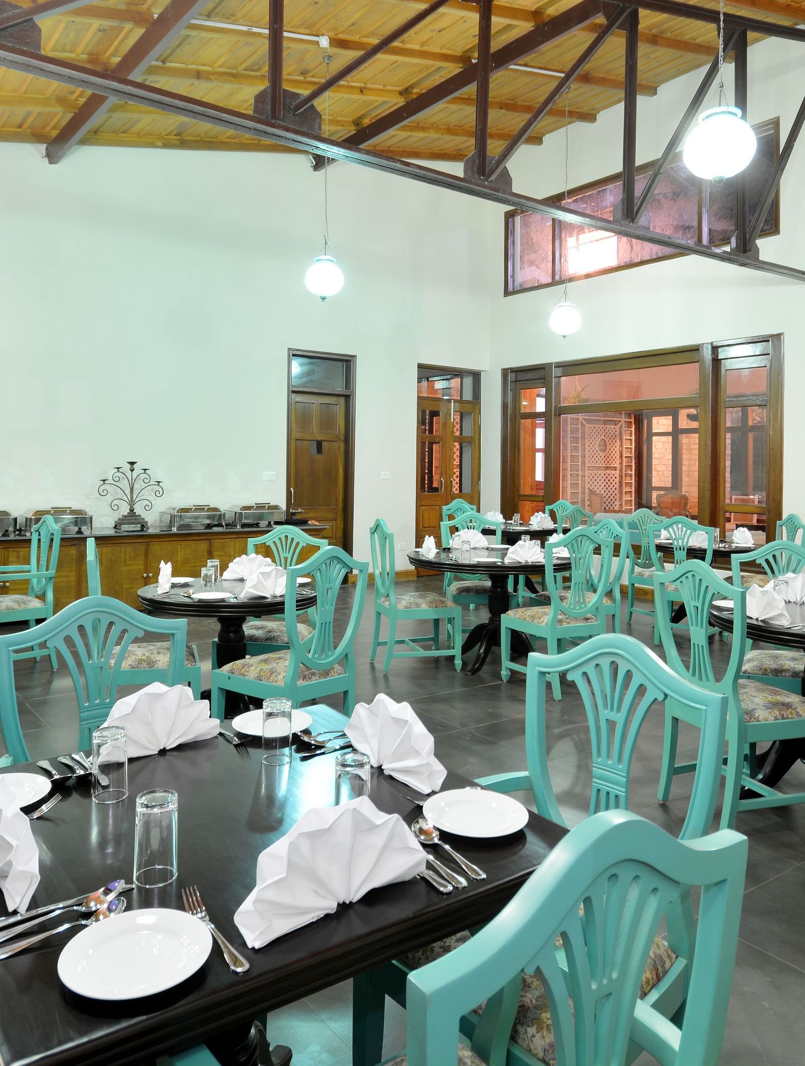 A vibrant dining area in Almora with well-arranged tables and chairs - BluSalzz Escapade - Anant Rasa Resort