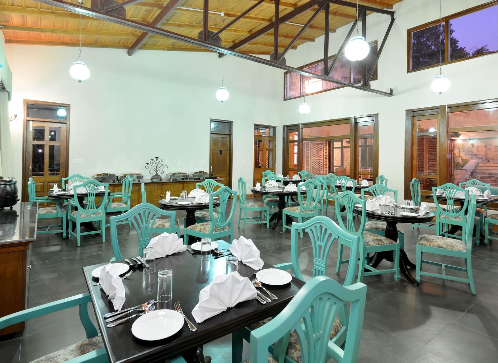 A vibrant dining area in Almora with well-arranged tables and chairs - BluSalzz Escapade - Anant Rasa Resort