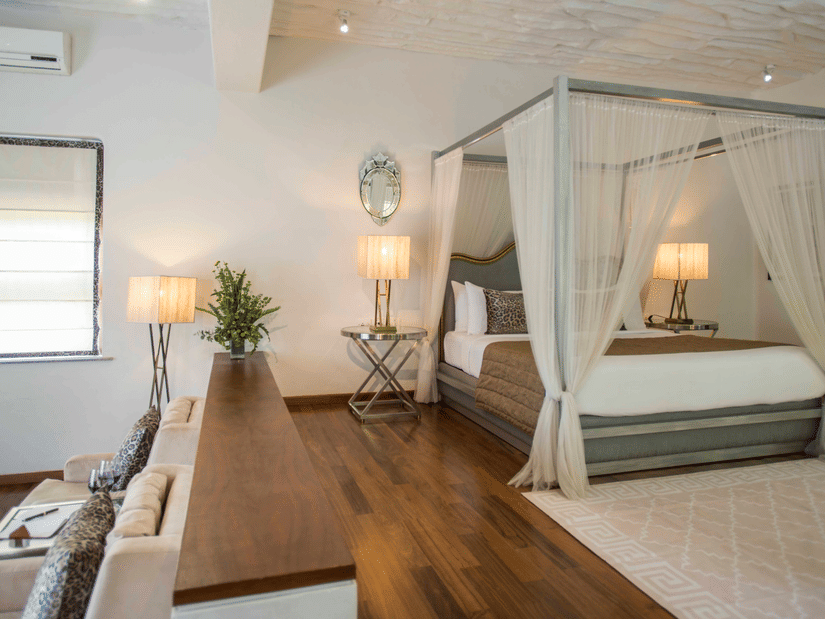 interior of well-equipped rooms at The Serai Bandipur featuring plush bed and lamp next to it with minimalistic decoration giving a rich vibe