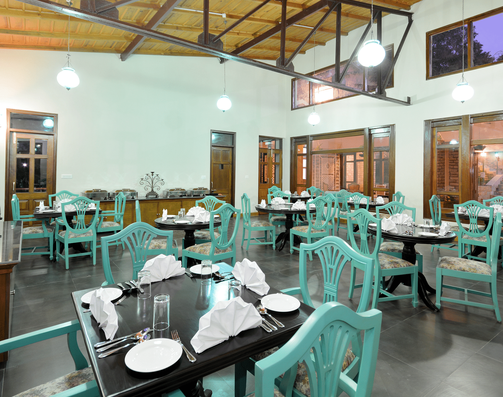 A vibrant dining area in Almora with well-arranged tables and chairs - BluSalzz Escapade - Anant Rasa Resort