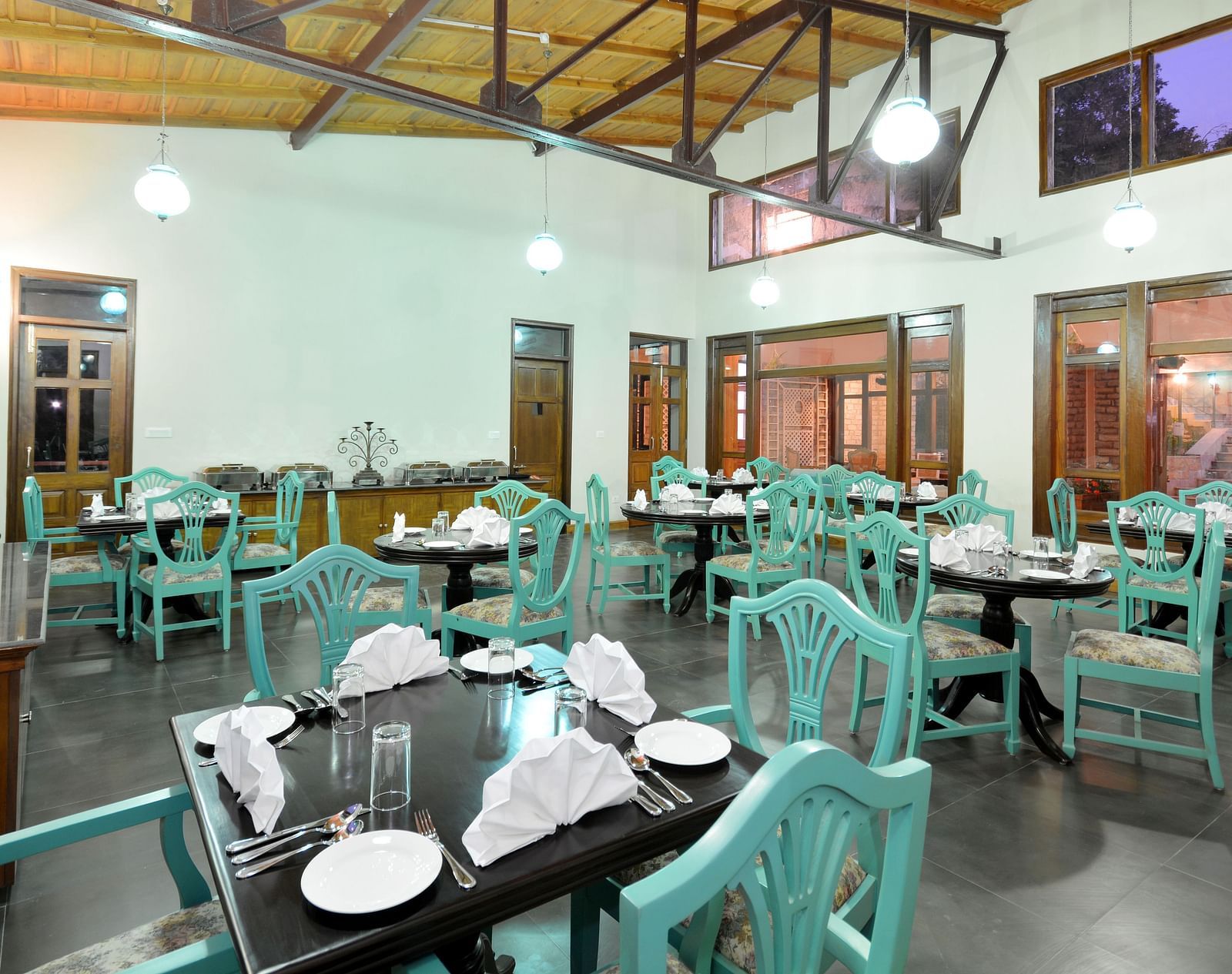 A vibrant dining area in Almora with well-arranged tables and chairs - BluSalzz Escapade - Anant Rasa Resort