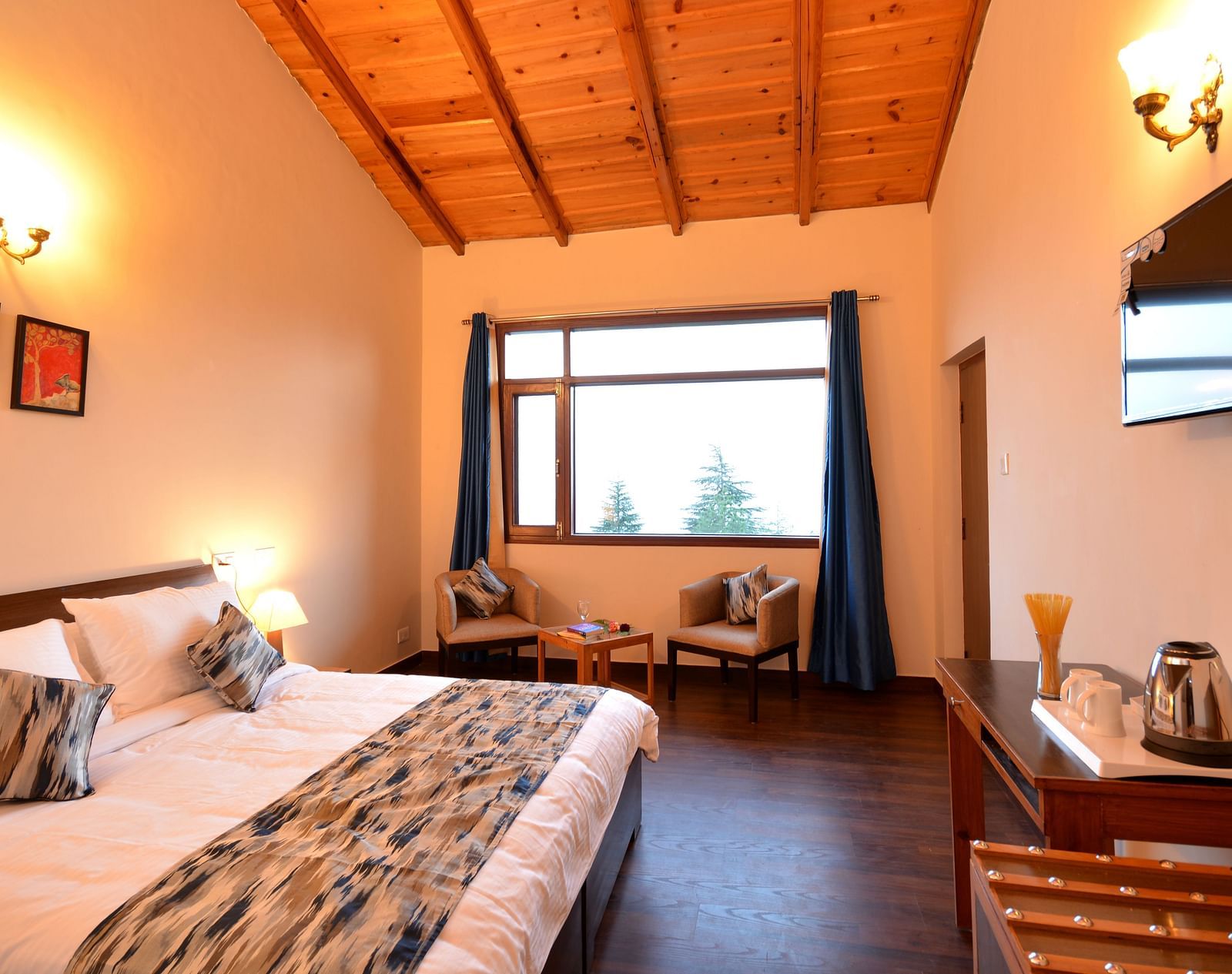 A spacious room in Shitlakhet featuring a comfortable bed and large windows overlooking greenery - BluSalzz Escapade - Anant Rasa Resort