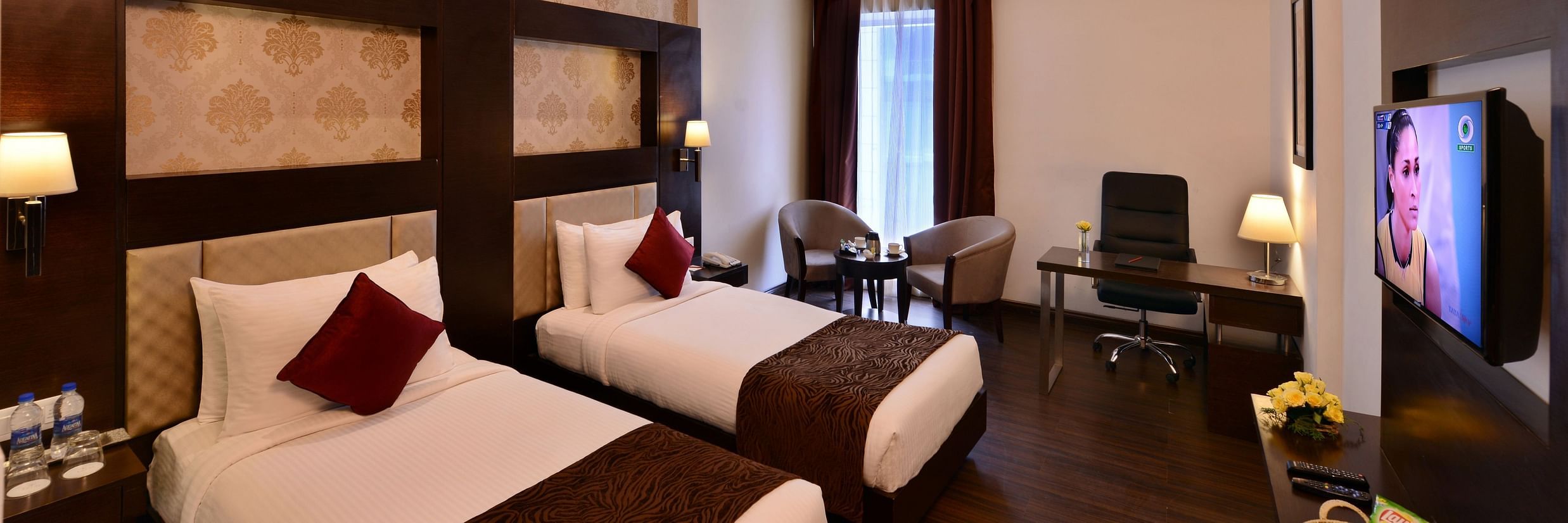 Image of Deluxe Rooms with Twin beds, a TV, chair and table