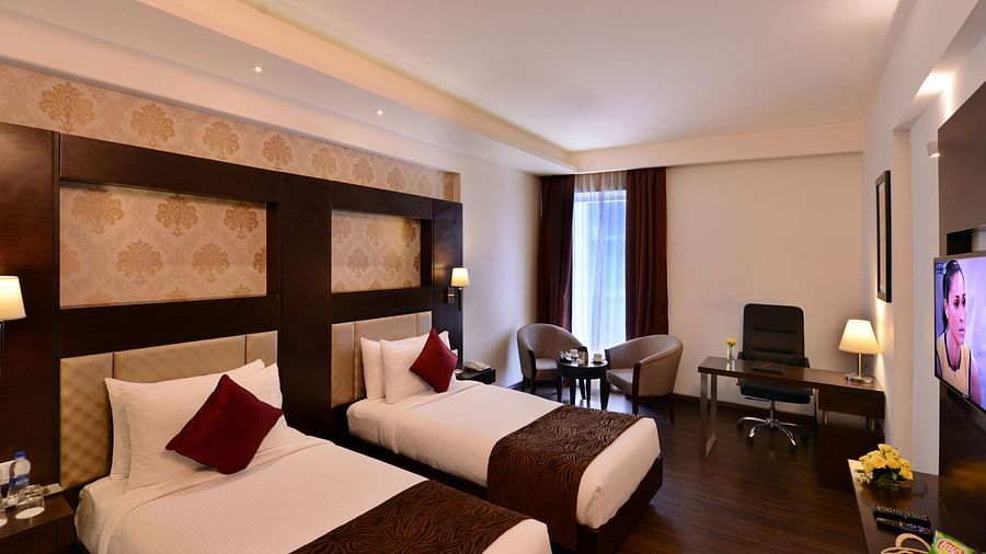 Image of Deluxe Rooms with Twin beds, a TV, chair and table