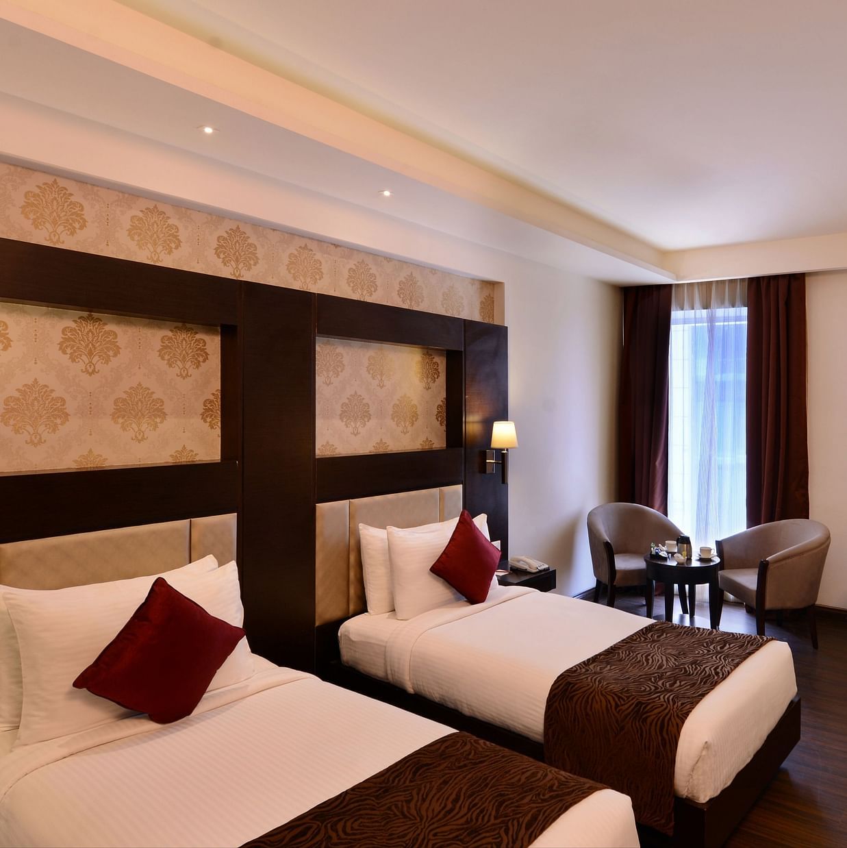 Image of Deluxe Rooms with Twin beds, a TV, chair and table