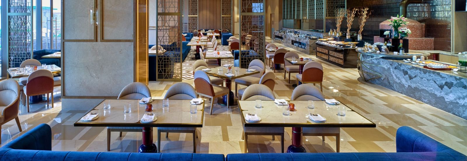 Modern indoor dining space with wooden accents and elegant table settings at Merlis Hotel, Coimbatore.