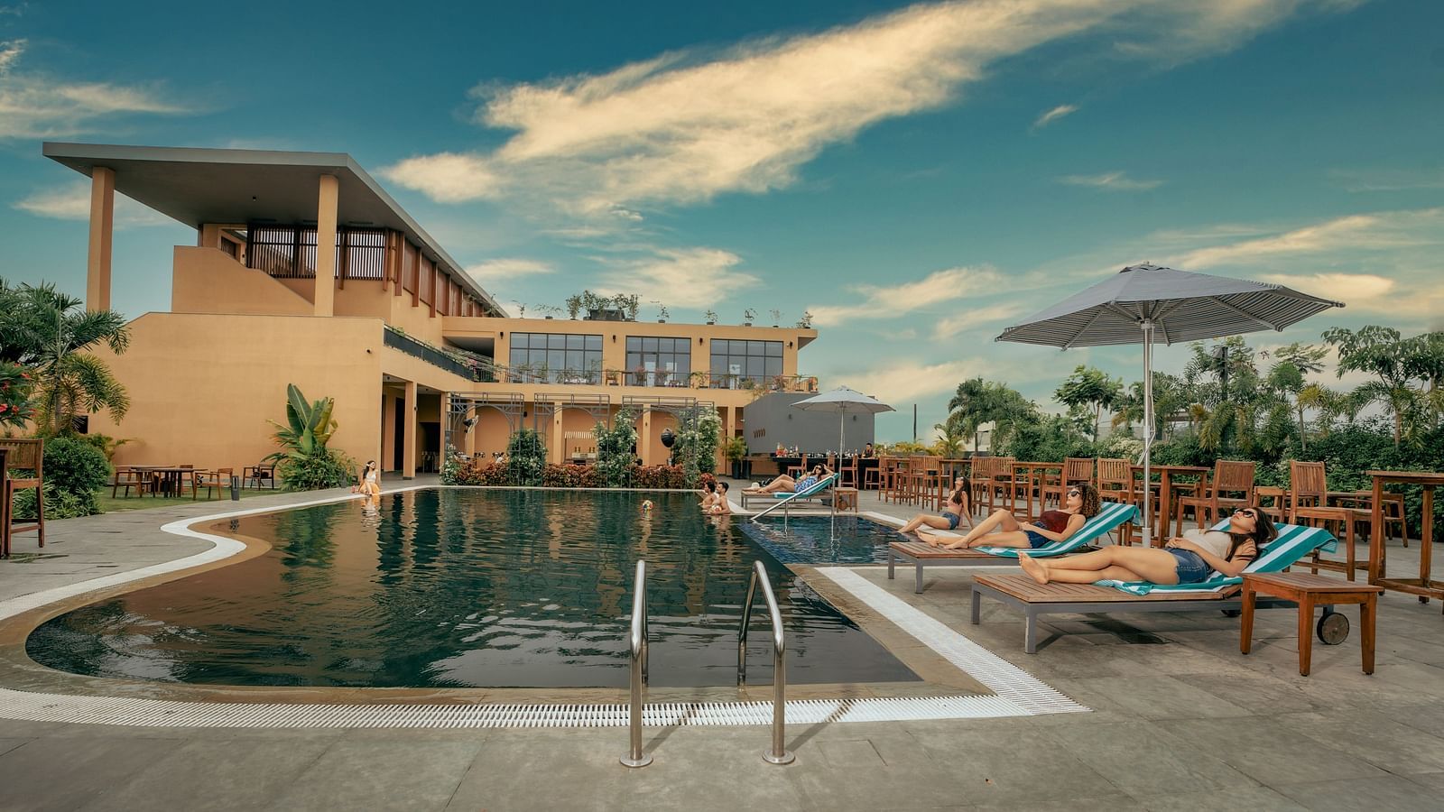 Outdoor swimming pool at Singalila Club with lounging chairs placed around the periphery