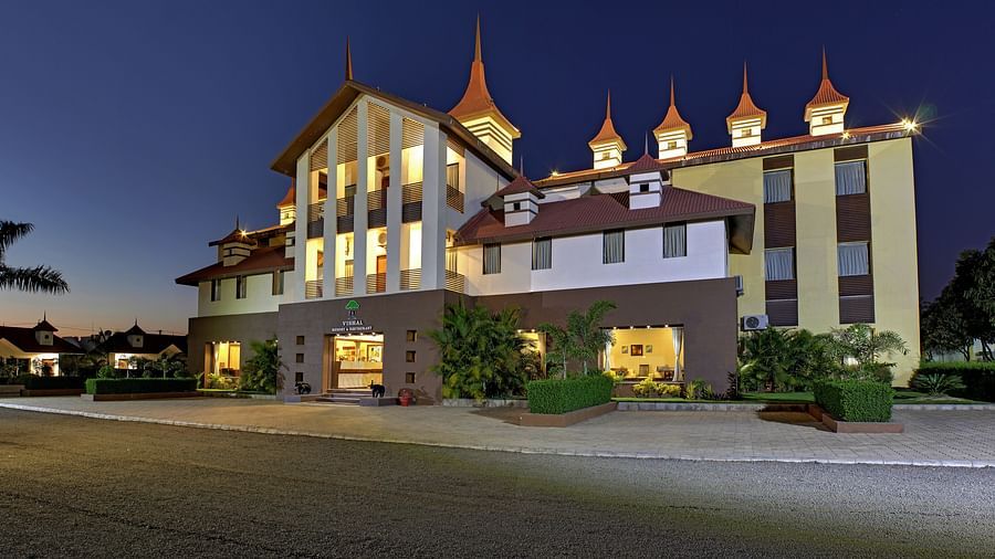 Exterior view of a our hotel building during late evening, illuminated with warm lights - Vishal Lords Inn Gir Forest