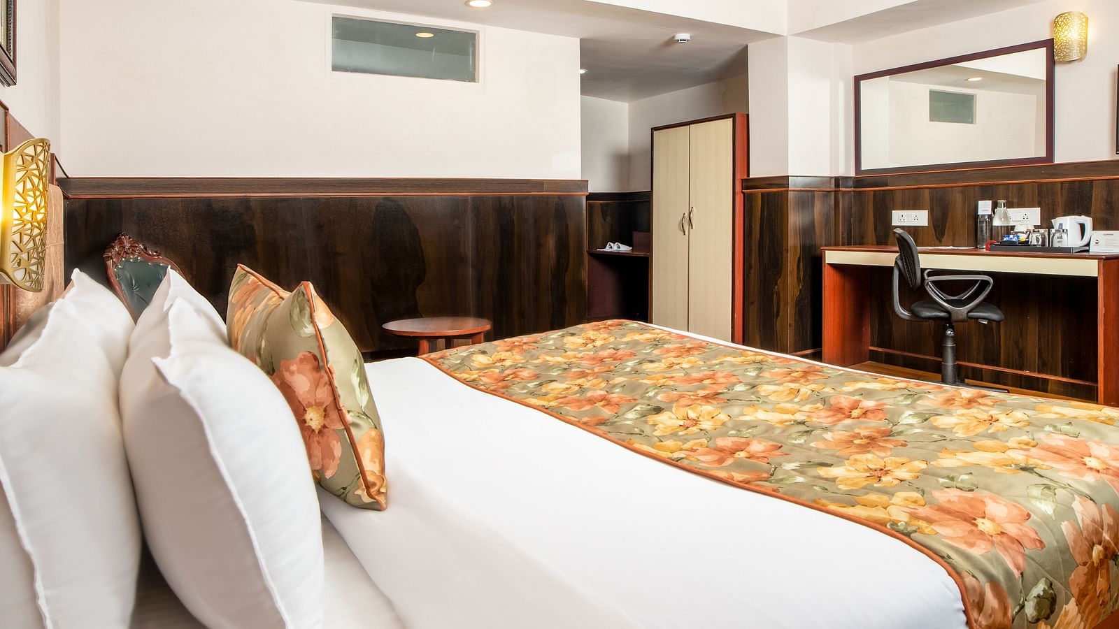 A side view of a bed in a room that has a chair and work desk | Summit Oakden Resort & Spa, Mall Road