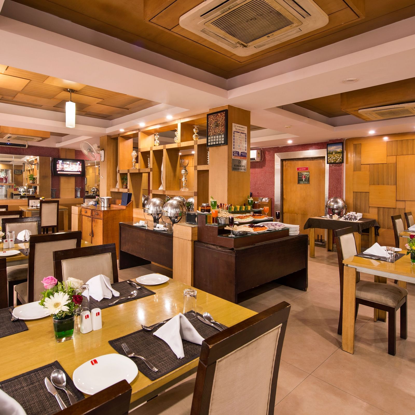A view of the hotel's dining area with warmly lit tables and chairs - Lords Eco Inn Dahej