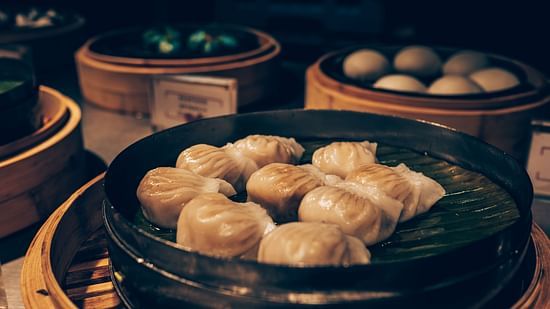 A bunch of momos served in a traditional bamboo steamer