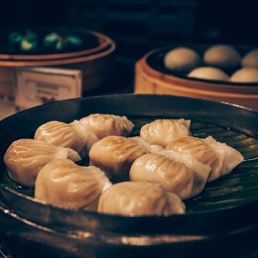 A bunch of momos served in a traditional bamboo steamer