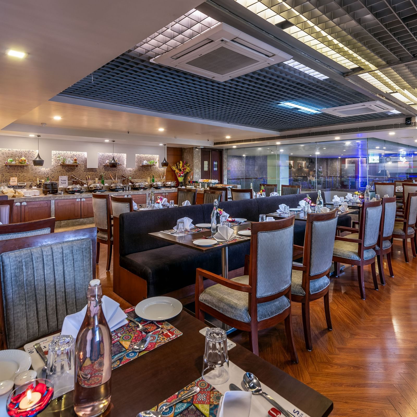 Wide view of a spacious dining area with multiple tables and decorative ceiling at Lords Plaza Jaipur.