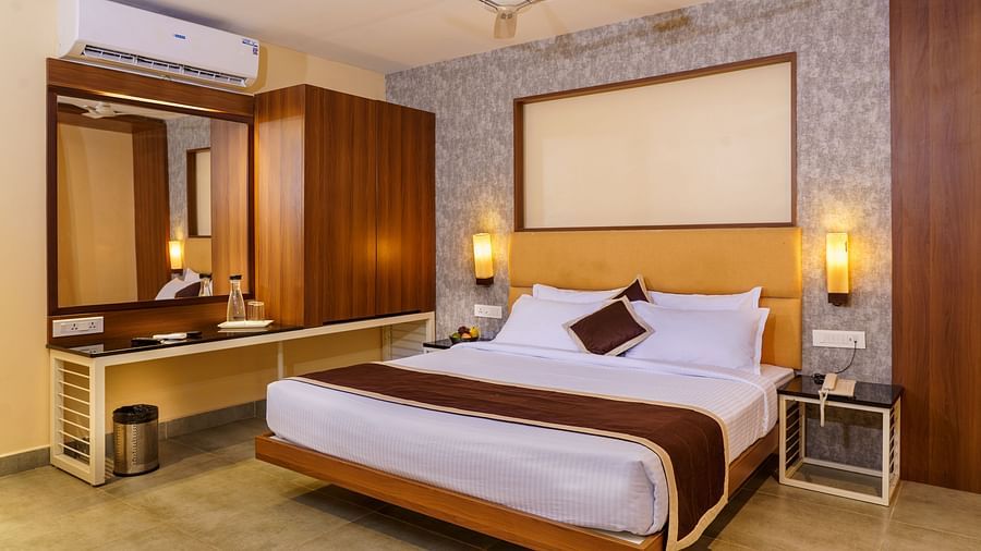 Deluxe room with dressing table and spacious bed at Wyt Hotels, Rameswaram