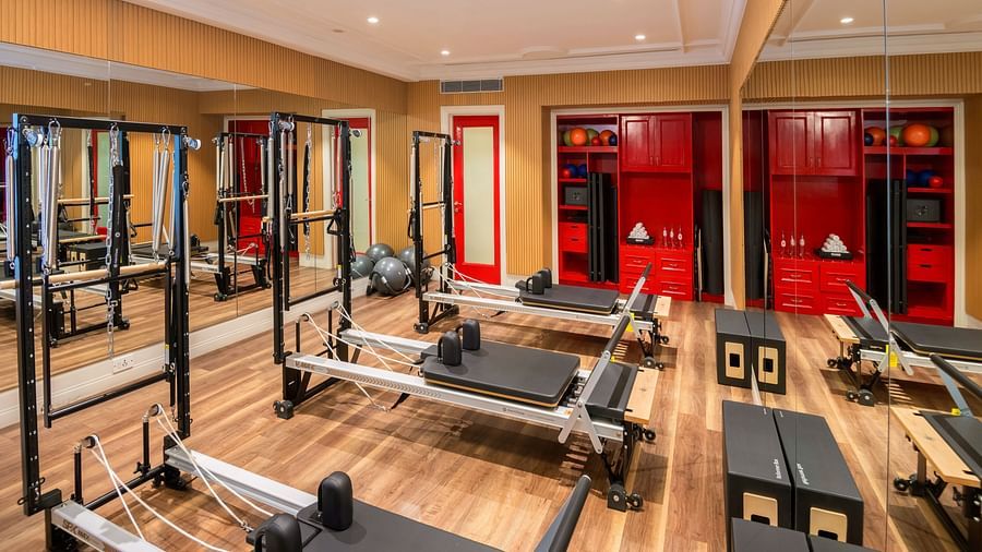 An image of the Pilates room with workout equipment and bright lighting at Sumaya at The Claridges gym in New Delhi